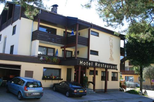 a hotel with two cars parked in front of it at das Christophorus in Söll