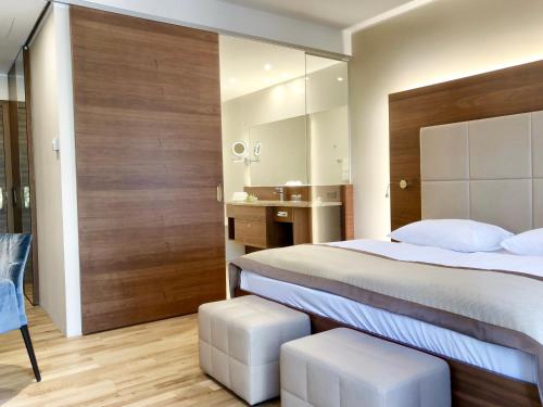 a bedroom with a large bed and a bathroom at Schlosspark Mauerbach - Adults only in Mauerbach