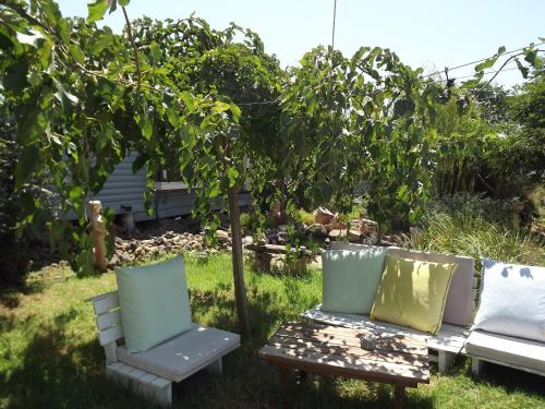 a garden with two chairs and a table and a tree at Villa Romantica in Ani'am