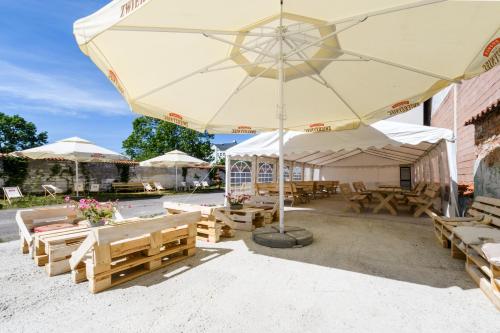 a patio with tables and chairs and a large umbrella at Hotel Sitarska in Biłgoraj