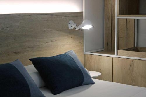 a bedroom with a bed with a blue pillow at Rocatel in Canet de Mar