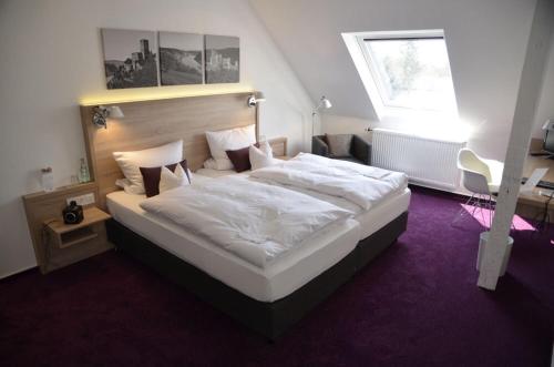 sypialnia z dużym białym łóżkiem w pokoju w obiekcie Tannenheim w mieście Boppard