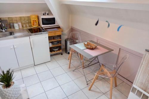 une petite cuisine avec une table et un micro-ondes dans l'établissement Studio Confort, en face du campus 1 et du tramway, à Caen