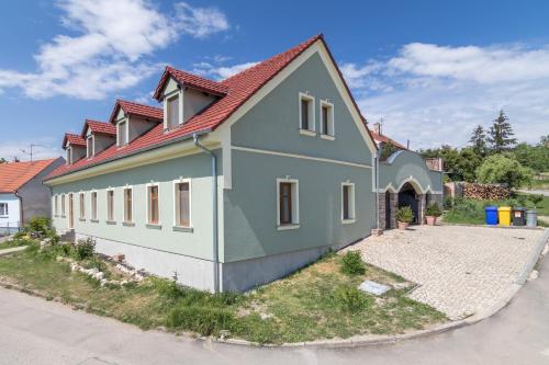 a green and white house with a red roof at Apartmány Fojtova studna in Sedlec