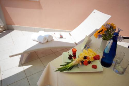 a table with a plate of fruit and flowers on it at Albergo Belsoggiorno in Sanremo