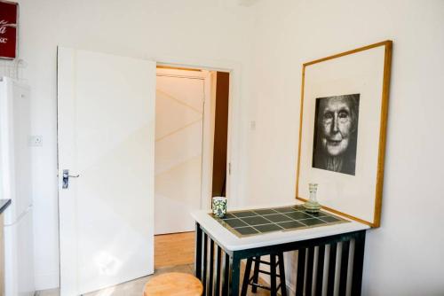 a room with a table and a picture on the wall at London's Central East End 2 Bedroom City Apartments in London