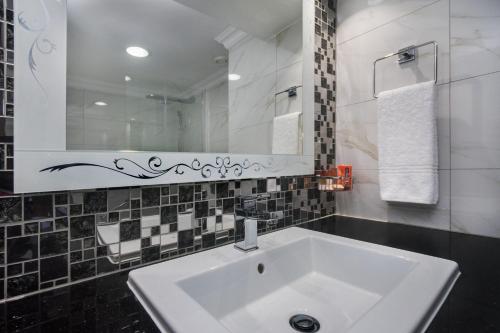 a bathroom with a white sink and a mirror at BON Hotel Abuja in Abuja