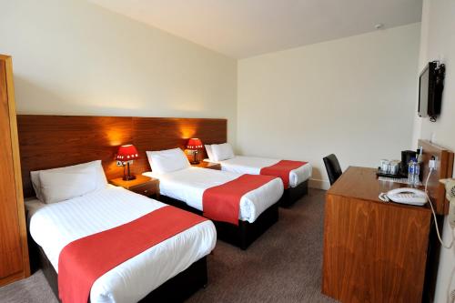 Habitación de hotel con 2 camas y escritorio en Alexander Thomson, en Glasgow