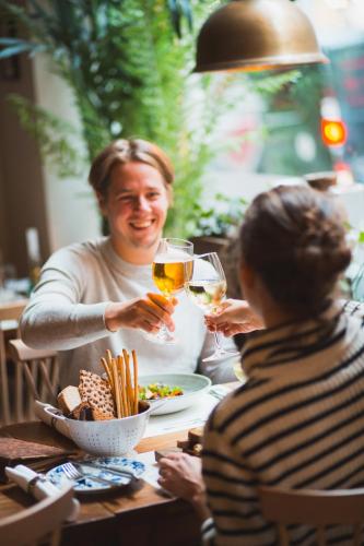 two people sitting at a table with glasses of wine at Hotel Kung Carl, WorldHotels Crafted in Stockholm