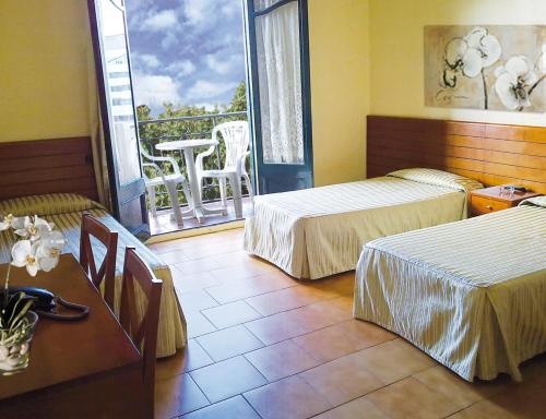 a hotel room with two beds and a balcony at Hotel Toledano Ramblas in Barcelona