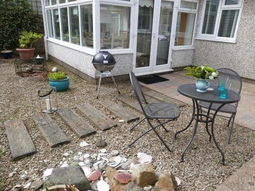 a patio with a table and a table and chairs at Swyn-Y-Mor in Morfa Nefyn