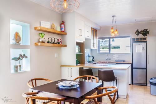 a kitchen with a table and chairs and a refrigerator at Mylas Cottage in Swakopmund