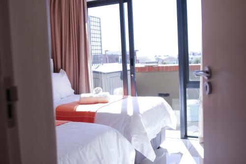 a hotel room with two beds and a window at Manhattan Suite-Canal Walk Mall in Cape Town