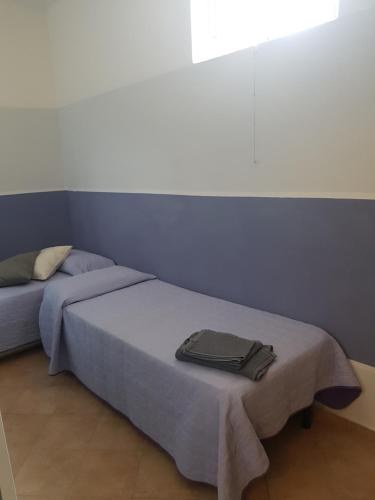een slaapkamer met een bed met een blauwe muur bij Casa Florine in Finale Ligure