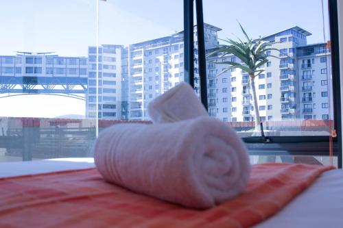a roll of toilet paper sitting on top of a bed at Manhattan Suite-Canal Walk Mall in Cape Town