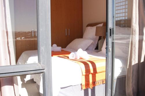 a view of a bedroom with a bed through a window at Manhattan Suite-Canal Walk Mall in Cape Town