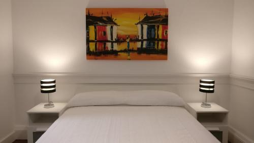 a bedroom with a bed with two lamps and a painting at Museum House in Funchal