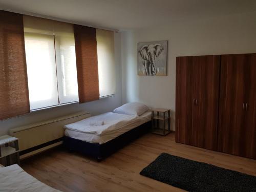 1 Schlafzimmer mit 2 Betten, einem Schrank und einem Fenster in der Unterkunft AB Apartment Objekt 26 in Stuttgart