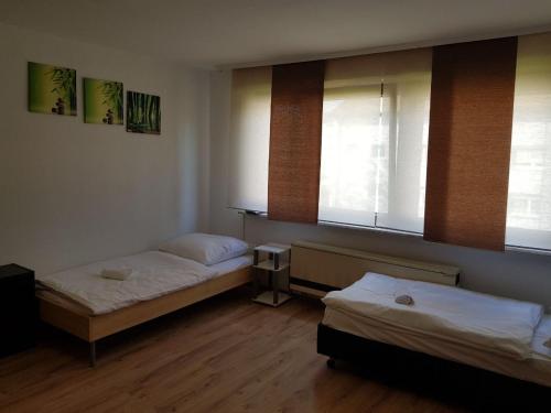 2 Betten in einem Zimmer mit 2 Fenstern in der Unterkunft AB Apartment Objekt 26 in Stuttgart