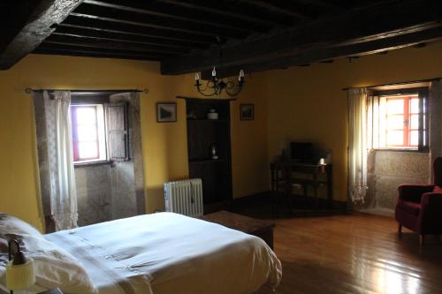 a bedroom with a white bed and two windows at Rectoral de Anllo in Sober
