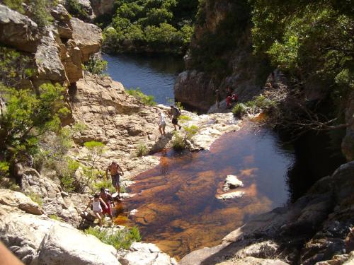 a group of people walking along a river at 185 on BEACH Boutique Suites in Gordonʼs Bay