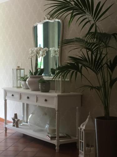 a white table with a mirror and a plant on it at Hotel Clodia - Adults Only in Sirmione
