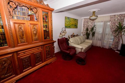 a living room with a chair and a wooden cabinet at Casa Andrei in Orşova