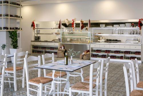 a dining room with a table and white chairs at Louis Paphos Breeze in Paphos City