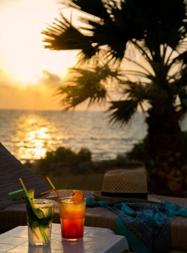two cocktails sitting on a table with a view of the ocean at Louis Paphos Breeze in Paphos City