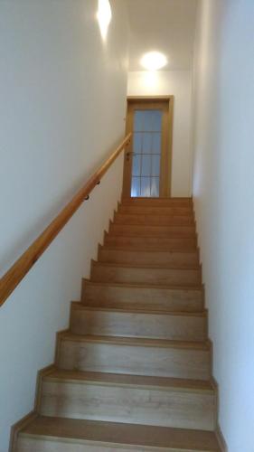 a stairway with wooden stairs with a door at Apartmány Nová Pec in Nová Pec
