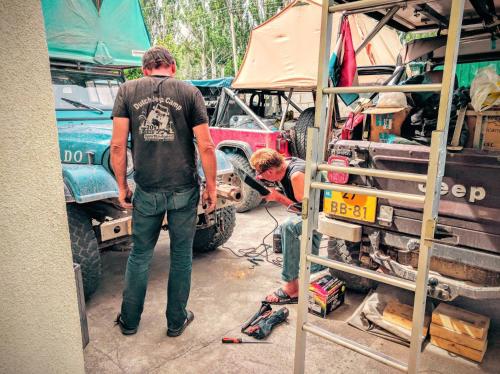 a man standing in a garage working on a truck at Hostel Nice in Karakol