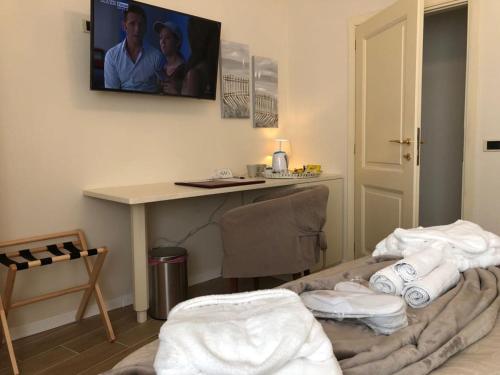 a room with a desk and a table with towels at BB Villa Magda in Novafeltria
