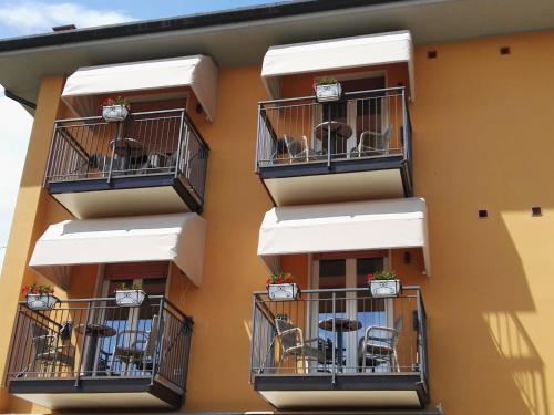 an apartment building with balconies with chairs and tables at Alessio Camere in Bardolino