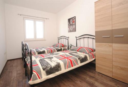 two twin beds in a bedroom with a dresser at Villa Guliver in Slatine