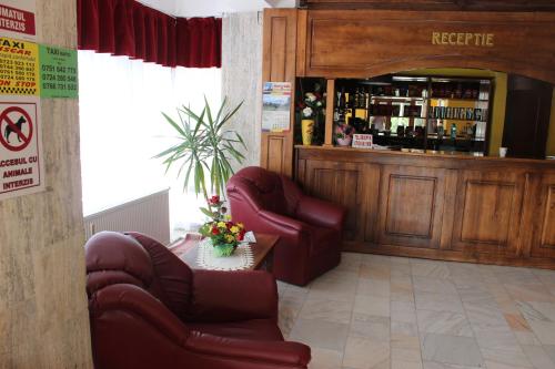 un restaurant avec deux chaises et un bar avec des boissons alcoolisées dans l'établissement Hotel Ciucas, à Vălenii de Munte