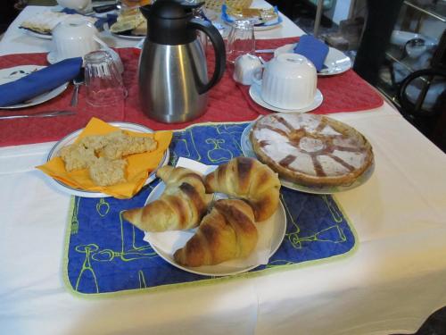 a table with two plates of pastries and a pie at B&B da NINA in Sabbioneta