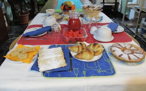 una mesa con un mantel blanco con comida. en B&B da NINA, en Sabbioneta