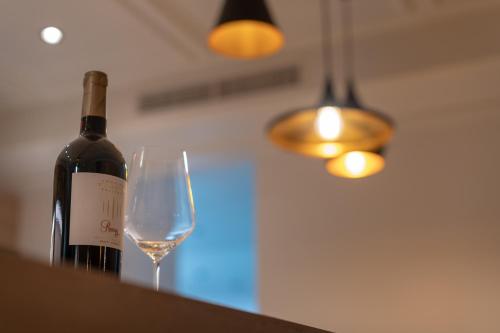 a bottle of wine and a glass on a counter at Vineus Tramin in Termeno