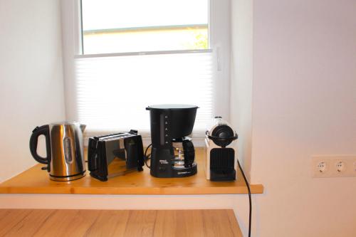 a counter with several appliances sitting on a shelf under a window at Ferienhaus in Langenlois in Langenlois