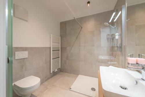 a bathroom with a toilet and a sink and a shower at Vineus Tramin in Termeno