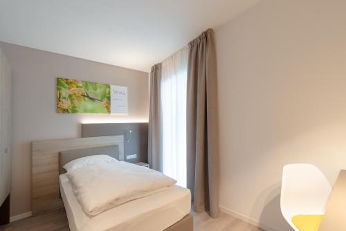 a bedroom with a bed and a window at Vineus Tramin in Termeno