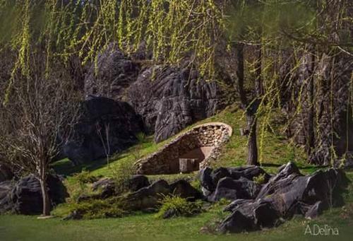 a stone bridge on a hill with trees and rocks at Omaya Eco Village in Gaytaninovo