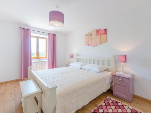 a bedroom with a large white bed and a window at VillaNuova in Šušnjevica