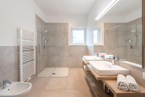 a bathroom with two sinks and a shower at Vineus Tramin in Termeno