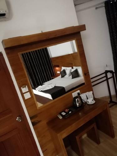 a reflection of a bedroom with a bed in a mirror at Kandyan View Holiday Bungalow free pickup from kandy in Kandy