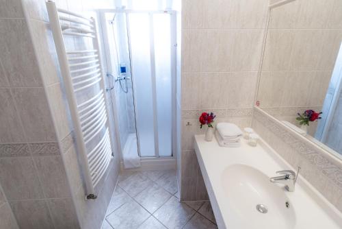 a bathroom with a tub and a sink and a shower at Penzion Fan in Karlovy Vary