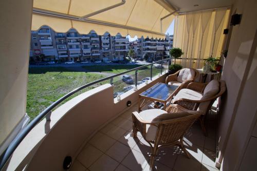 a balcony with chairs and a table and a view of a building at Deluxe boutique suite , jacuzzi, private parking, fireplace in Thessaloniki