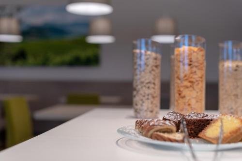 a table with a plate of food and glass containers of food at Vineus Tramin in Termeno