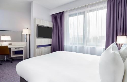 a hotel room with a large bed and a window at Leonardo Hotel Swindon in Swindon
