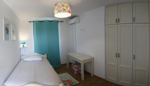 a small bedroom with a bed and a desk at VillaNuova in Šušnjevica